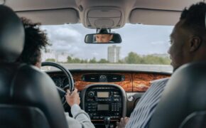 man in white long sleeve shirt driving car