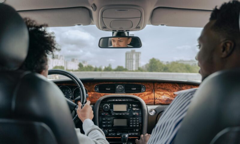 man in white long sleeve shirt driving car