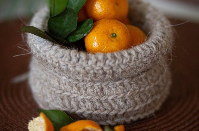 fresh oranges in rustic knitted basket close up