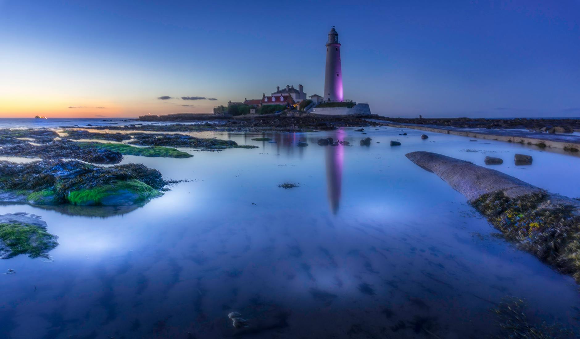 white lighthouse beside body of water