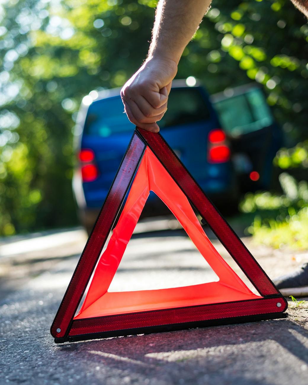 person placing warning triangle on road