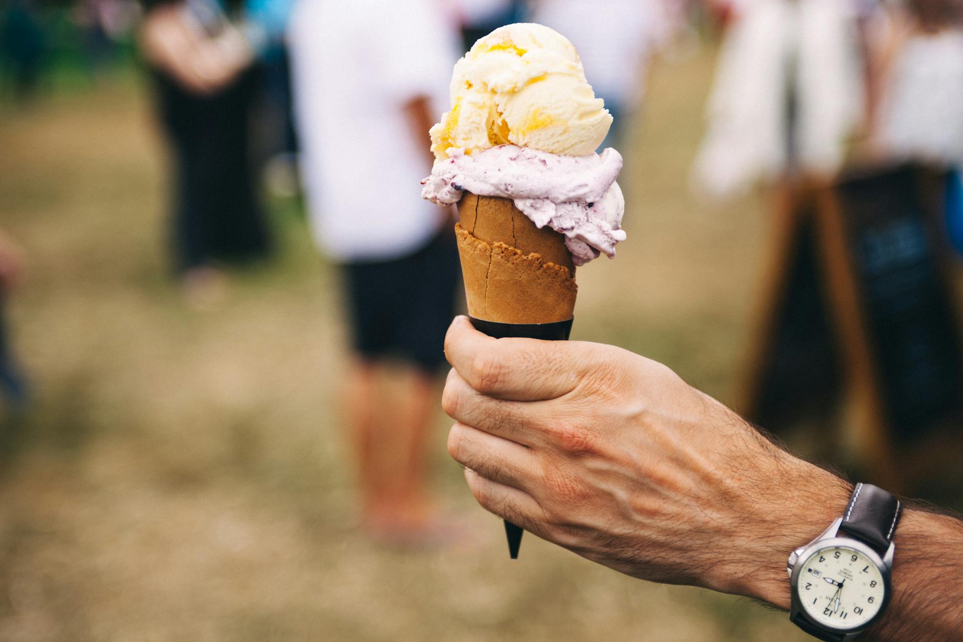person holding yellow and purple ice cream